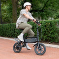 person riding j5 bike down the street in a helmet