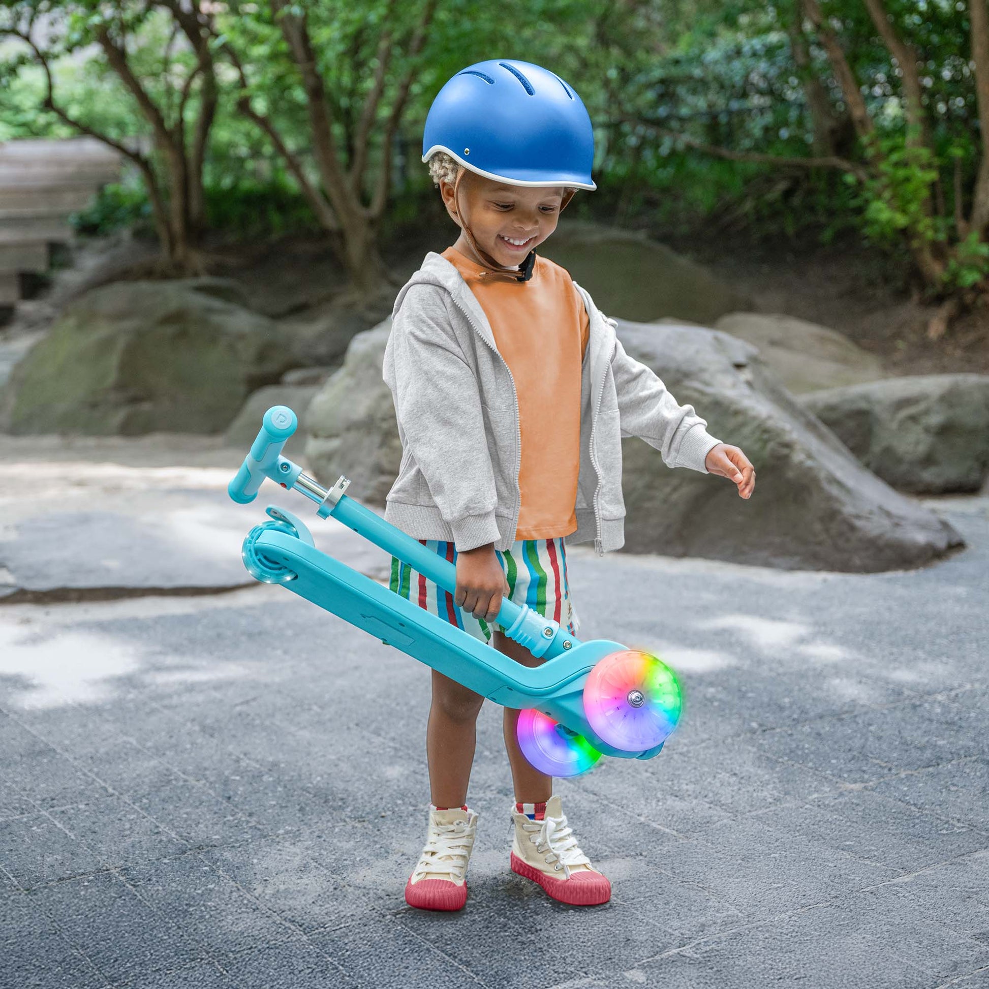 kid holding folded blue bloom kick scooter