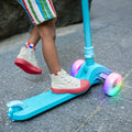 kid standing on blue bloom kick scooter