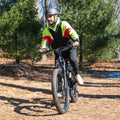 man riding core e-bike through the woods