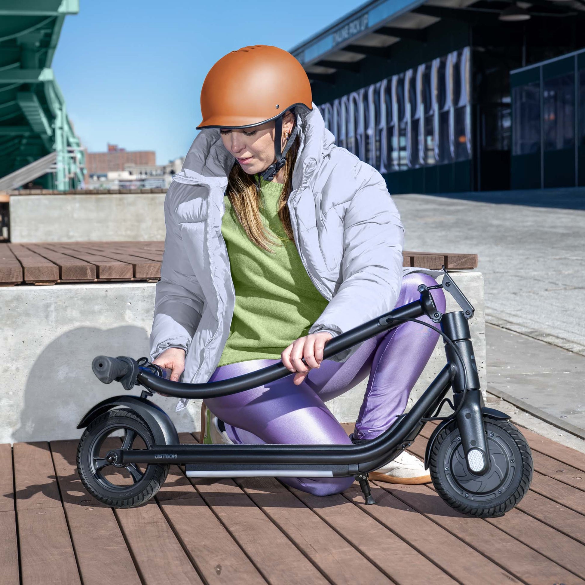 person folding ember e-scooter stem down