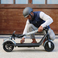 person folding eris pro electric scooter in half