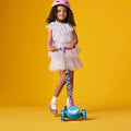 young girl in a helmet standing on frozen kick scooter