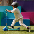young kid riding gem kick scooter on grass