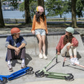 three kids sitting in a skate park with their hex kick scooters
