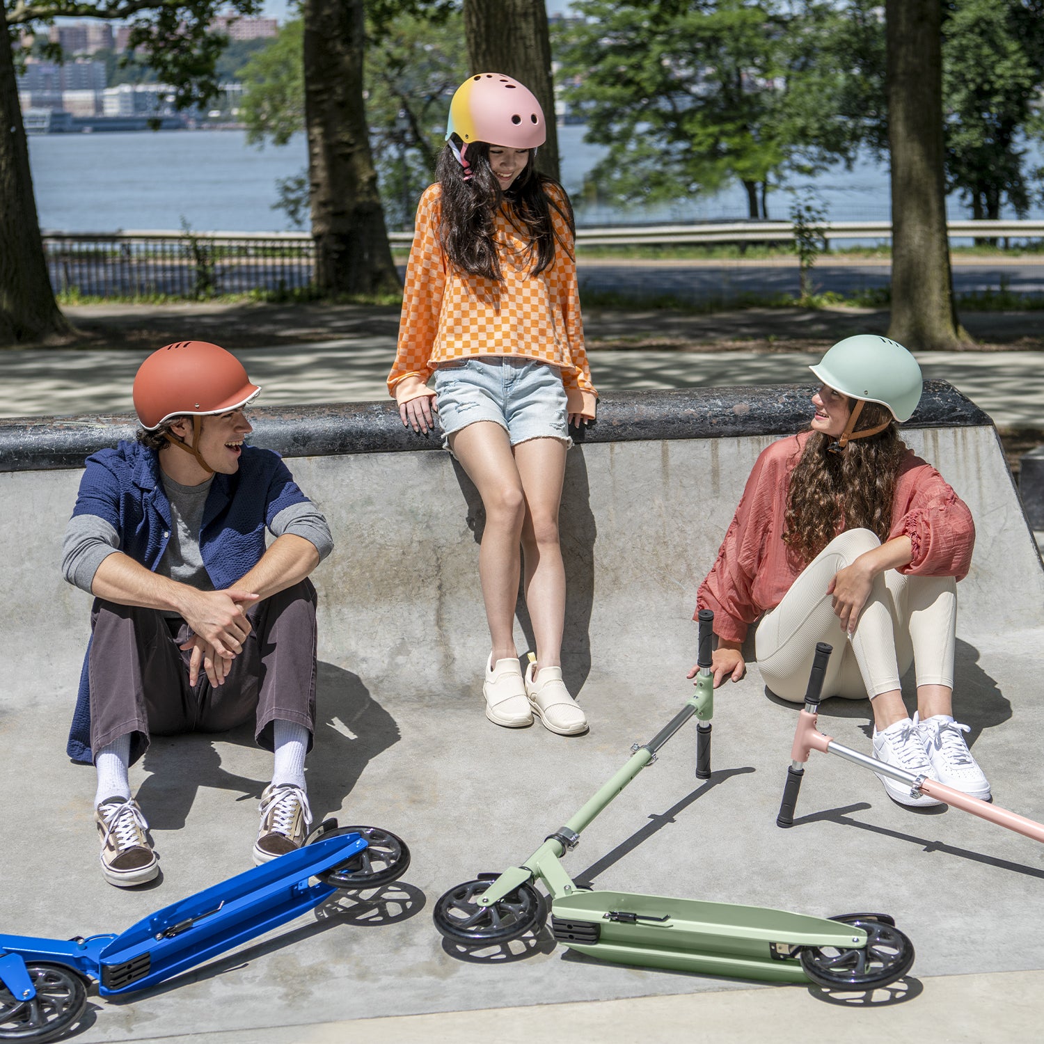 three kids sitting in a skate park with their hex kick scooters