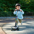little kid riding black leap kick scooter