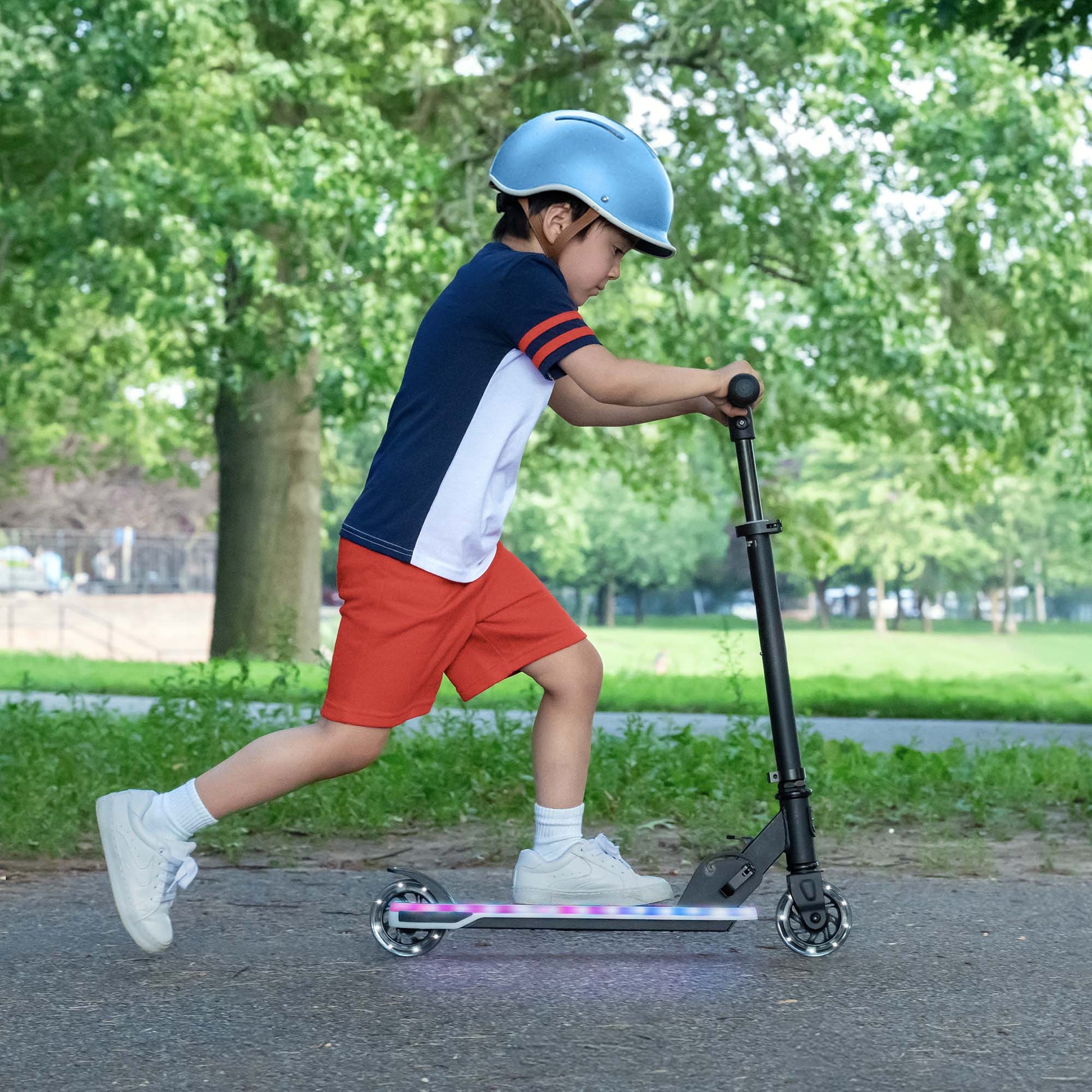 kid riding kick scooter in the park