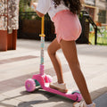 young kid riding the princess kick scooter with one foot on the scooter deck