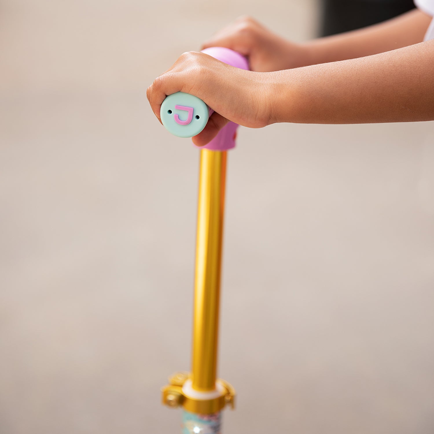 close up of kid holding the handlebar on the princess kick scooter