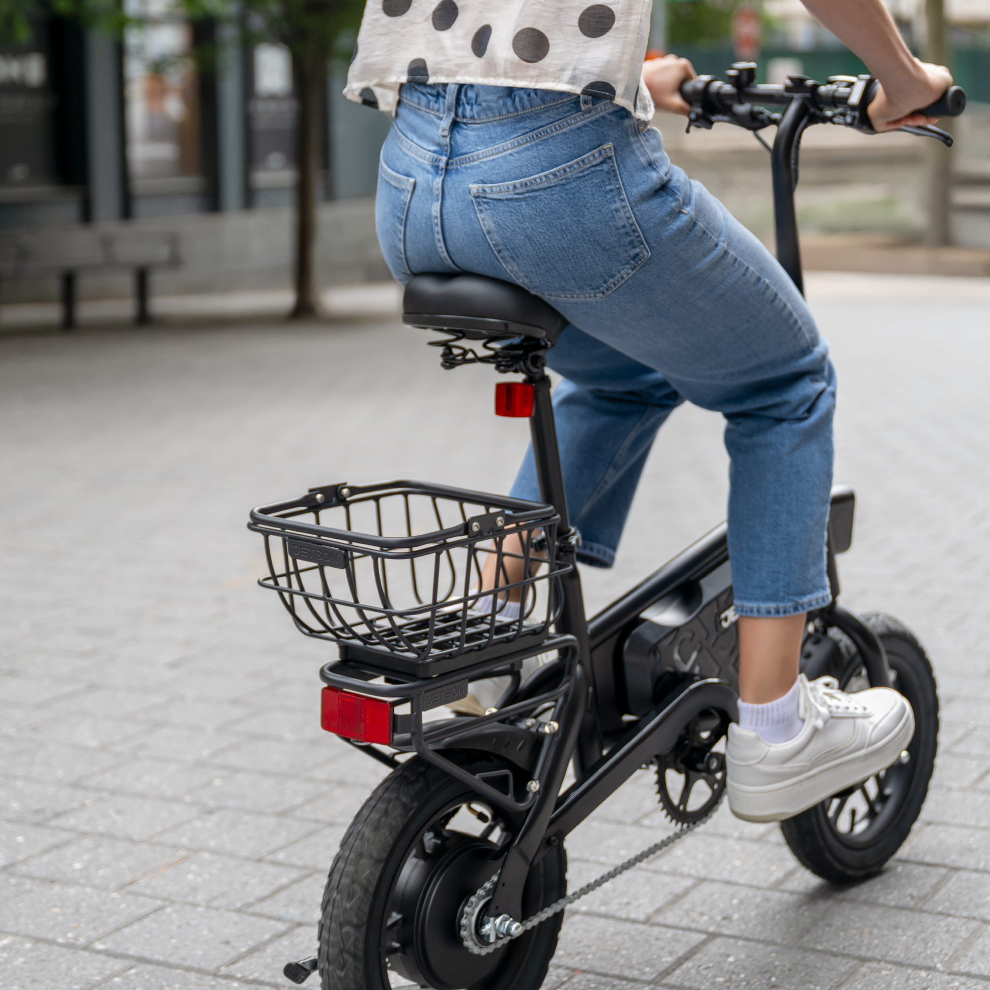 person riding bike with metal basket attached to rear rack