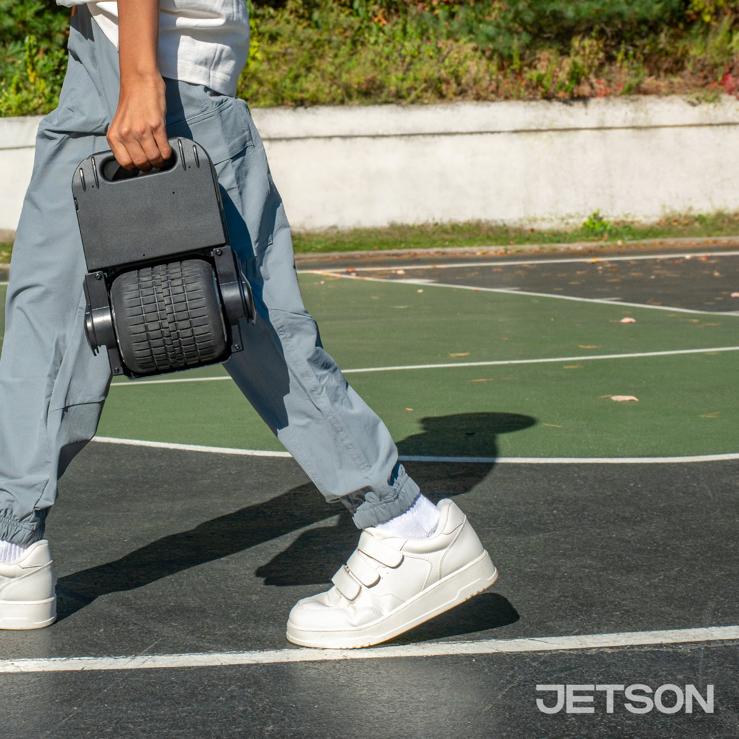 kid carrying a folded ring balance board by handle