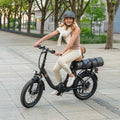 woman riding Venture electric bike with yoga mat attached to back