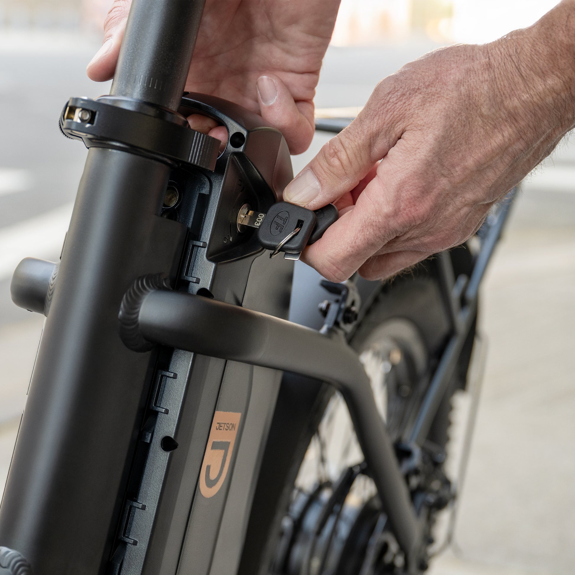 person locking battery on Venture electric bike