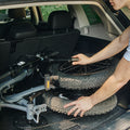 folded warren electric bike in the trunk of a car