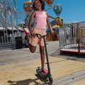 young kid riding the echo electric scooter through an amusement park