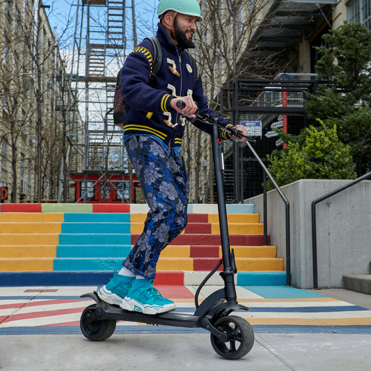 man riding e-scooter and smiling