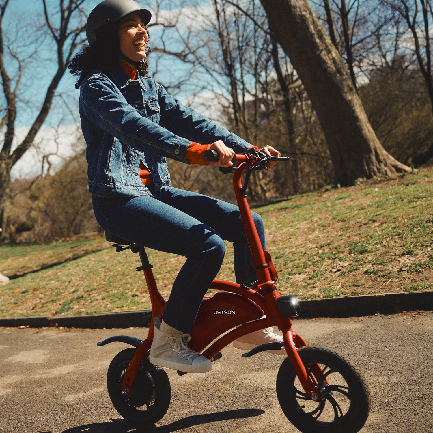 woman laughing while riding Bolt bike through a park