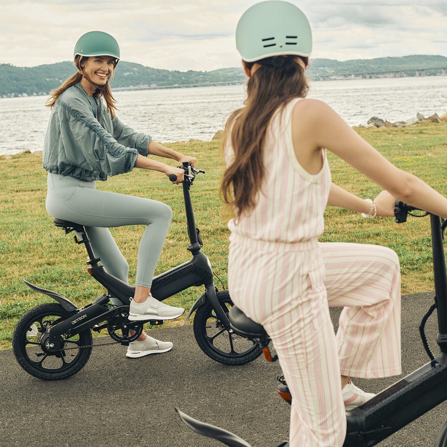 2 women on their Haze bikes out in nature and one is smiling at the other