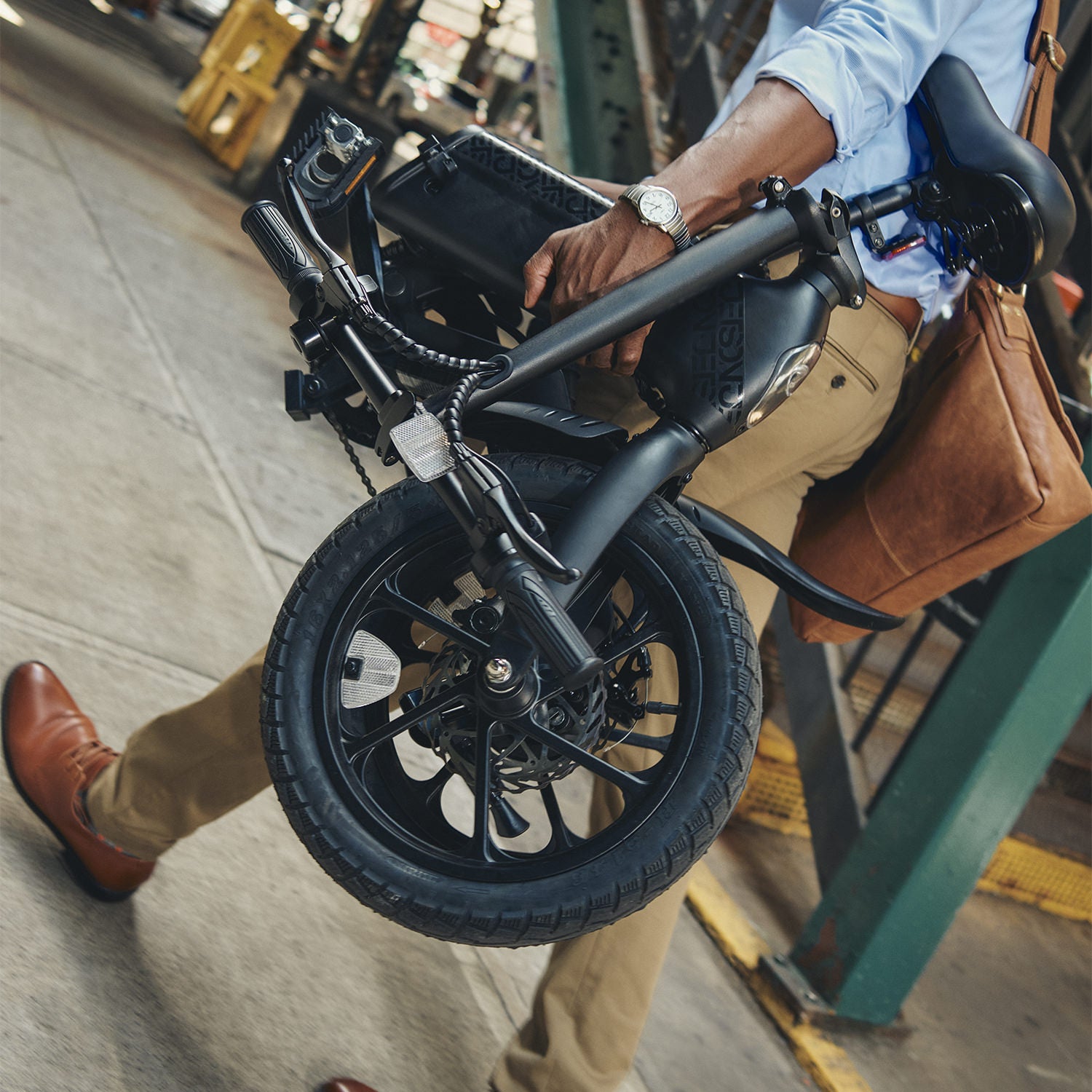person walking with and holding folded Haze electric bike