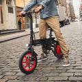 person straddling the arro bike on a cobblestone street