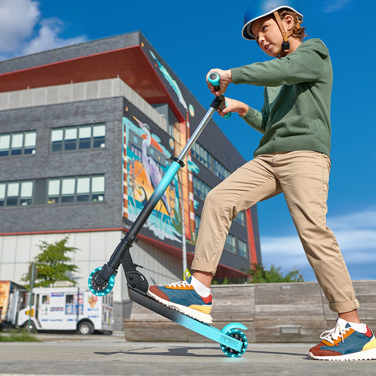 kid with one foot on black and blue juno kick scooter