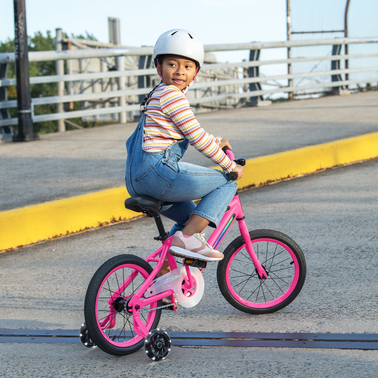 young kid riding pink light rider 16 bike