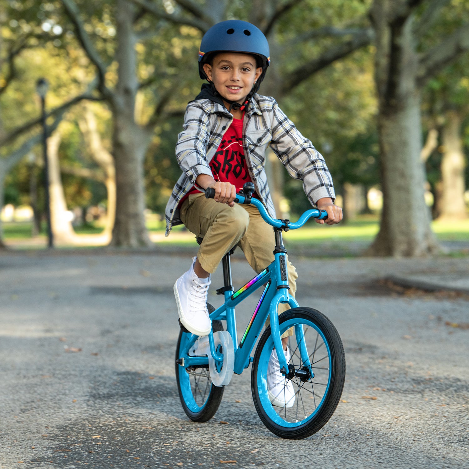 young kid riding blue light rider 16 bike