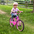 little girl riding JLR X through the grass
