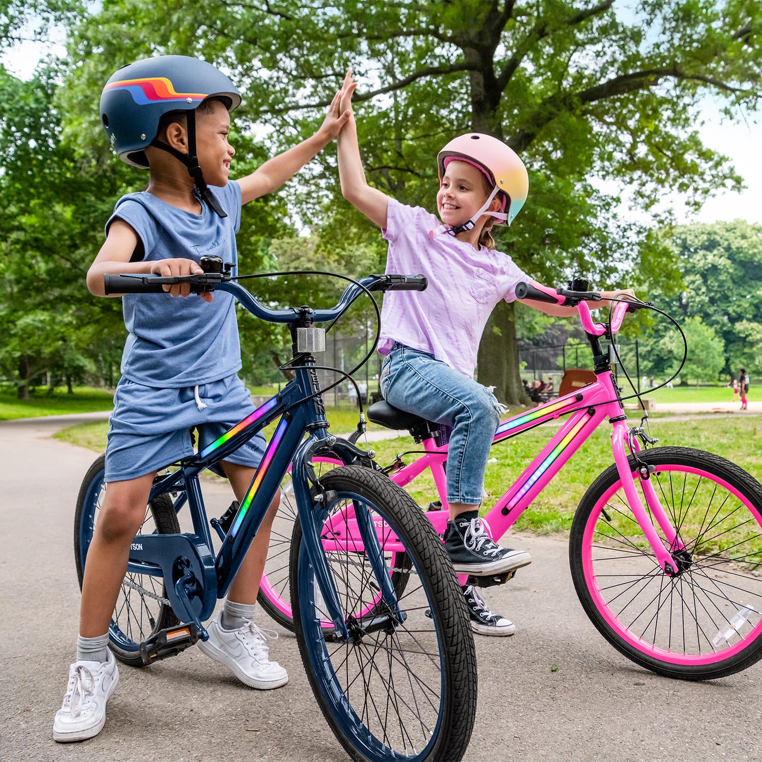 two children on their JLR X bikes high fiving each other