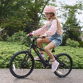 kid riding black light up bike through a park