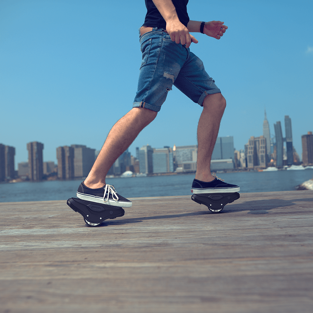 person riding their MotoKicks on a pier across from the island of Manhattan