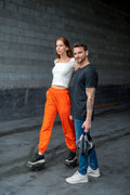 two people standing together and the person on the left is standing on their MotoKicks and the other one holding theirs