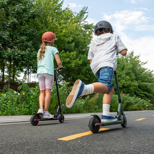 two kids riding black and camo relay scooters