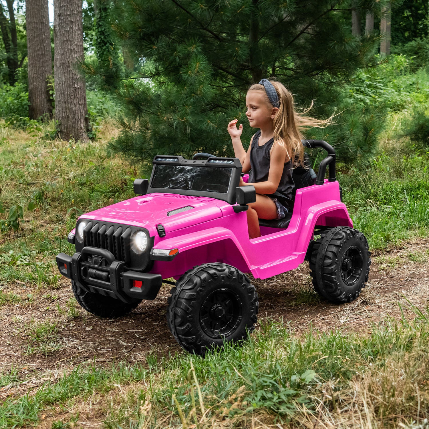 kid driving pink safara ride-on down a path