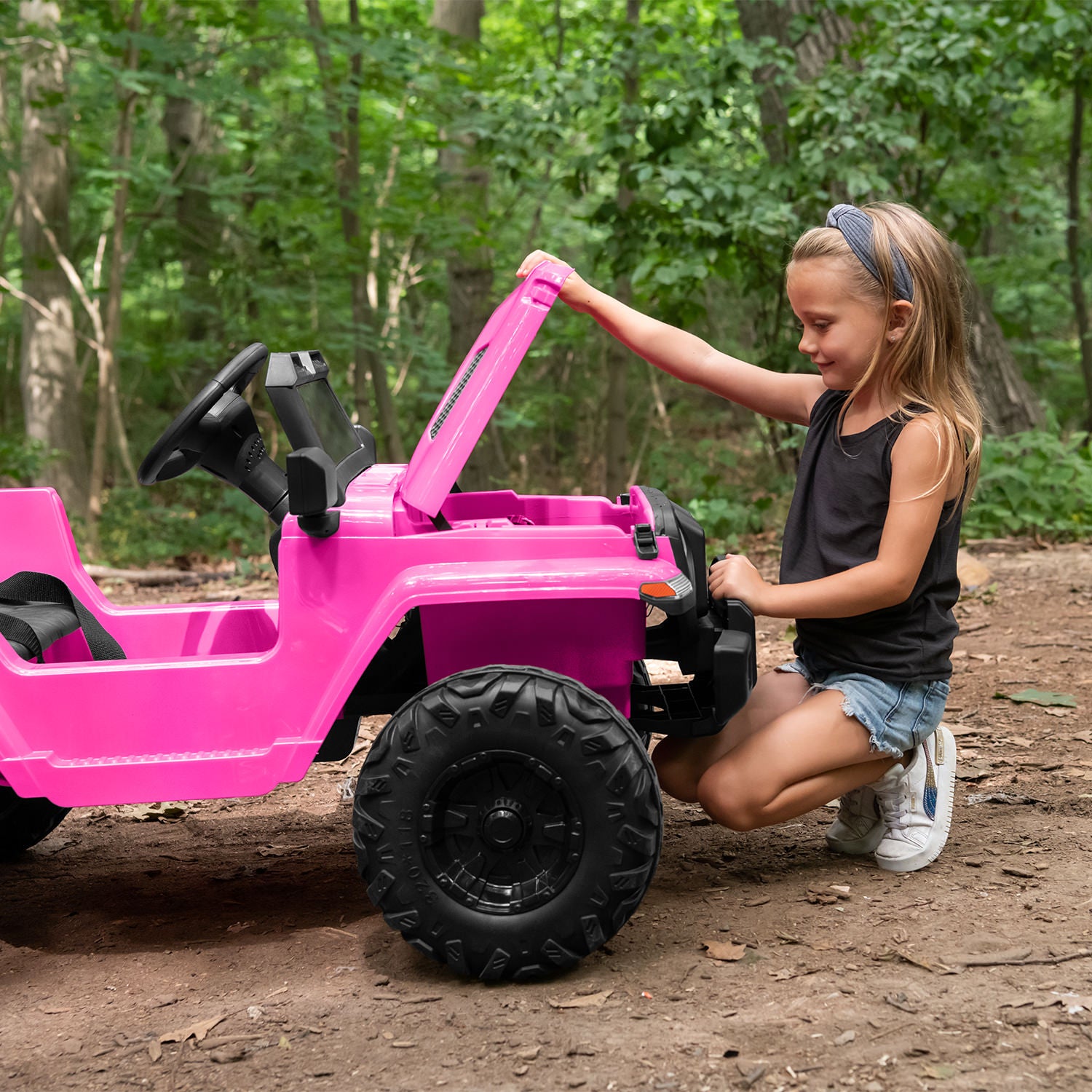 kid opening front hood of pink safara ride-on