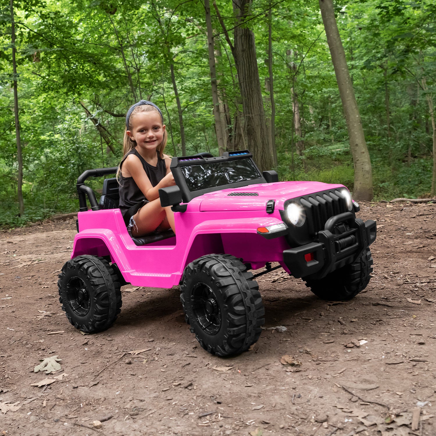 kid driving pink safara ride-on in the woods