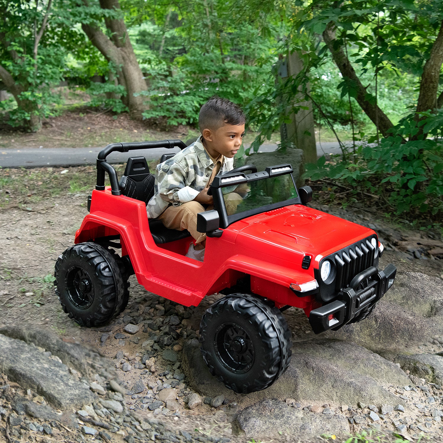 kid driving red safara ride-on on the path