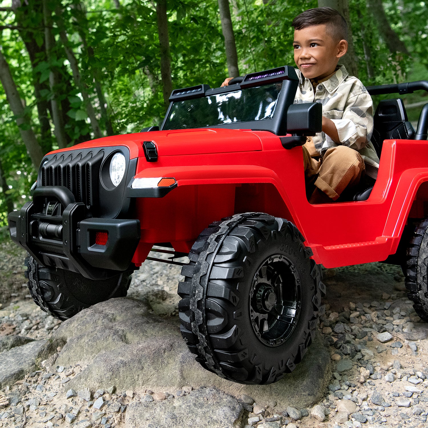 kid sitting in a red safara ride-on