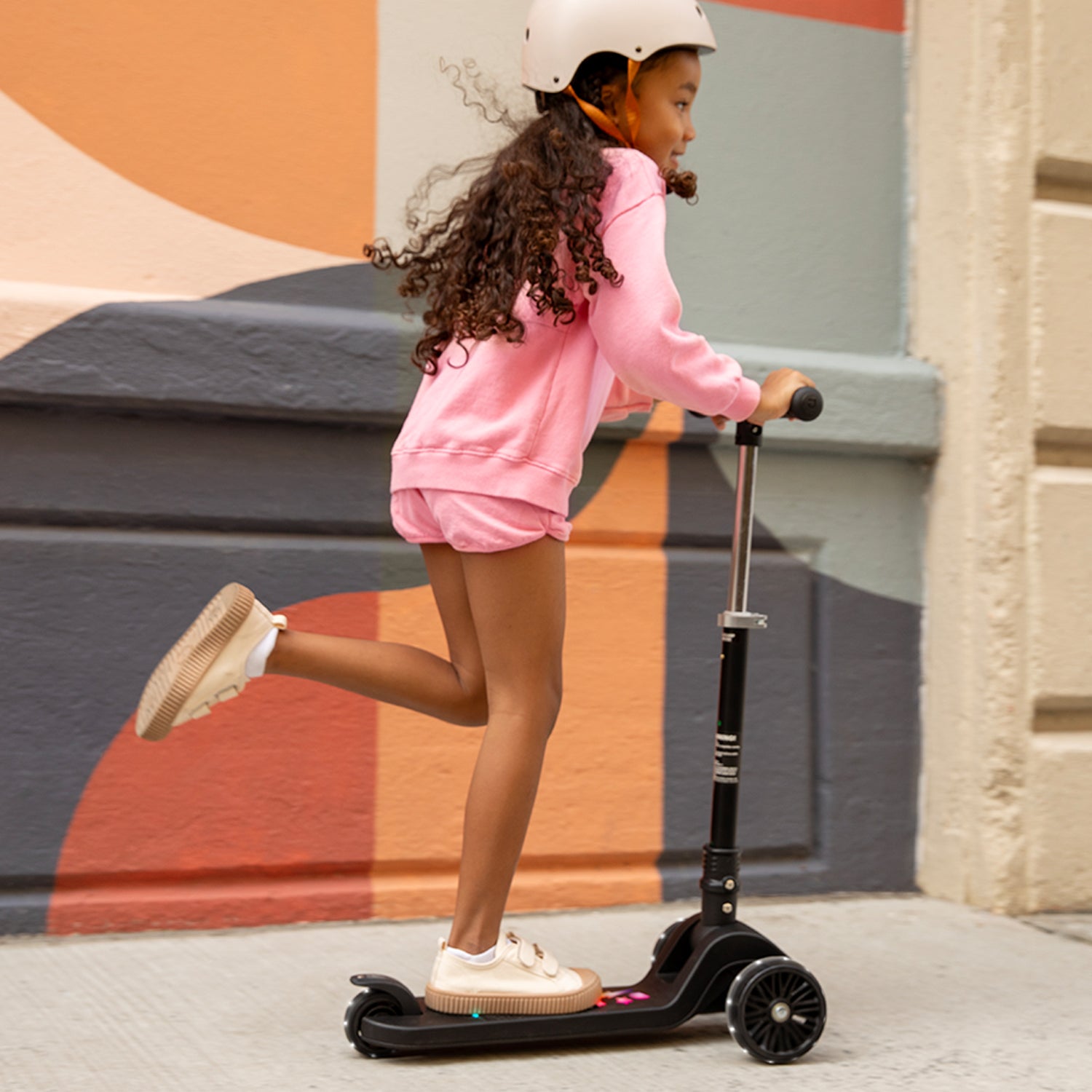 young kid riding amber kick scooter