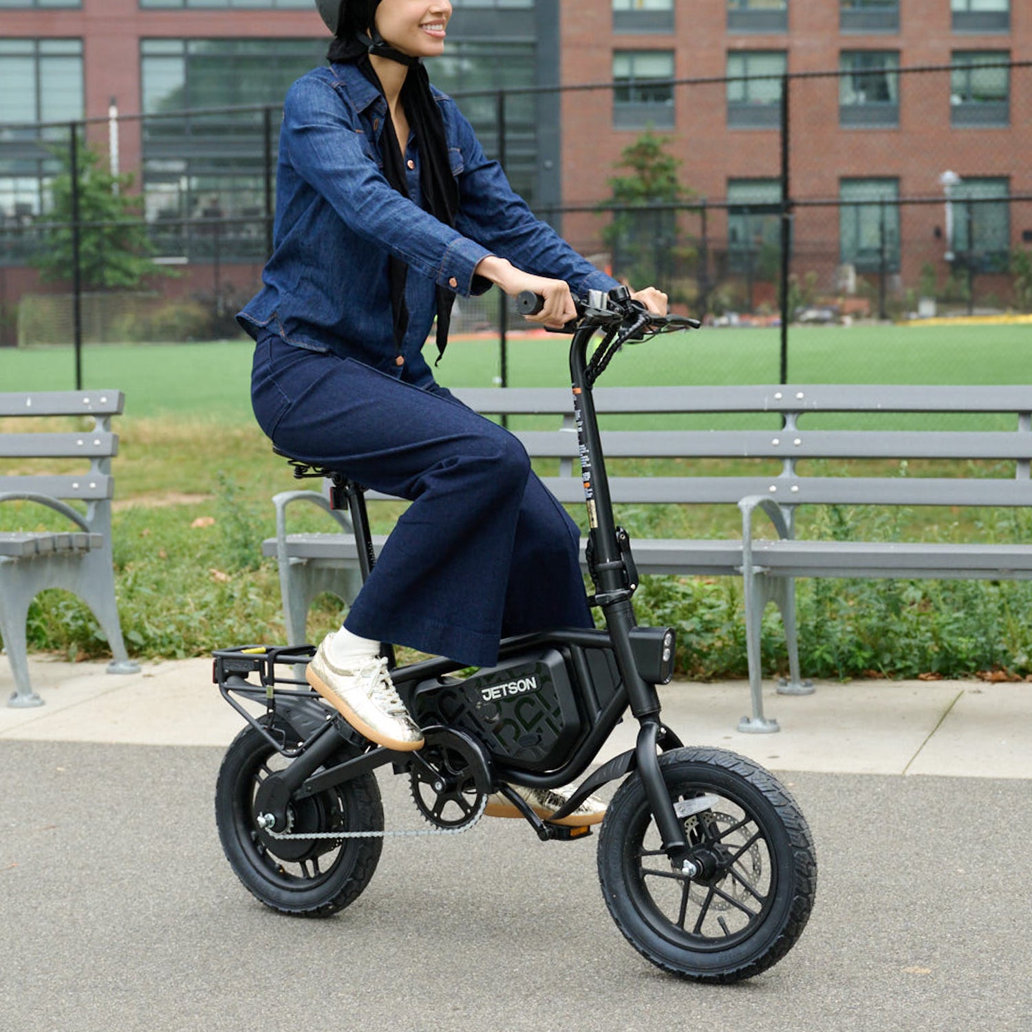 woman riding bolt pro max electric bike through a park