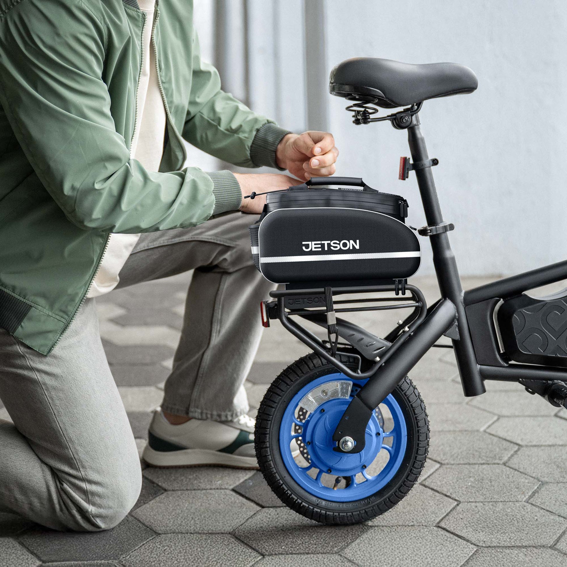 guy kneeling with bolt x electric ride on rackit saddle bag