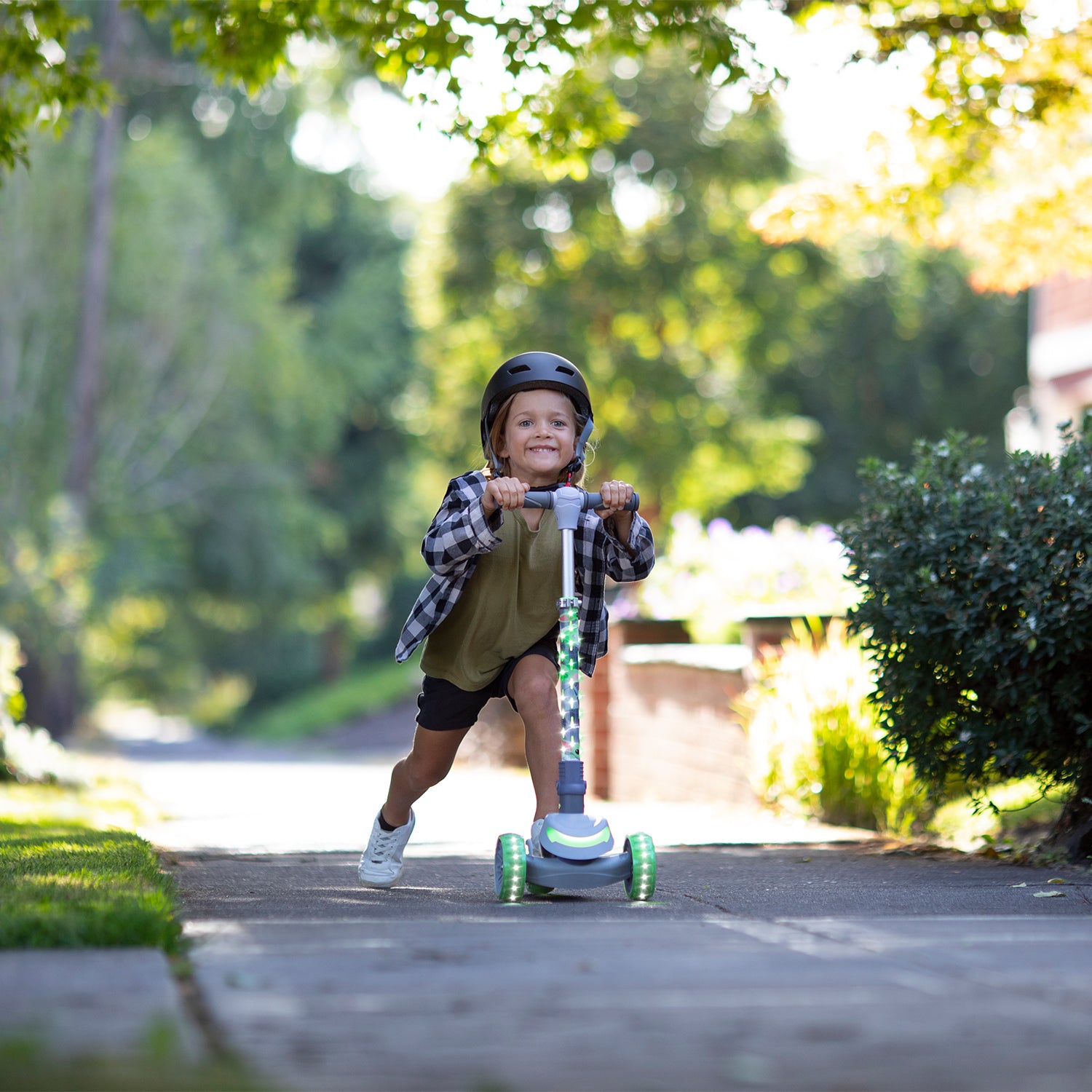 young kid riding the disney grogu kick scooter on the sidewalk