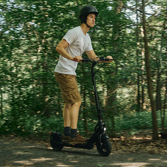 person riding the copperhead scooter on a path in the woods