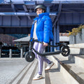 person carrying folded ember electric scooter down steps