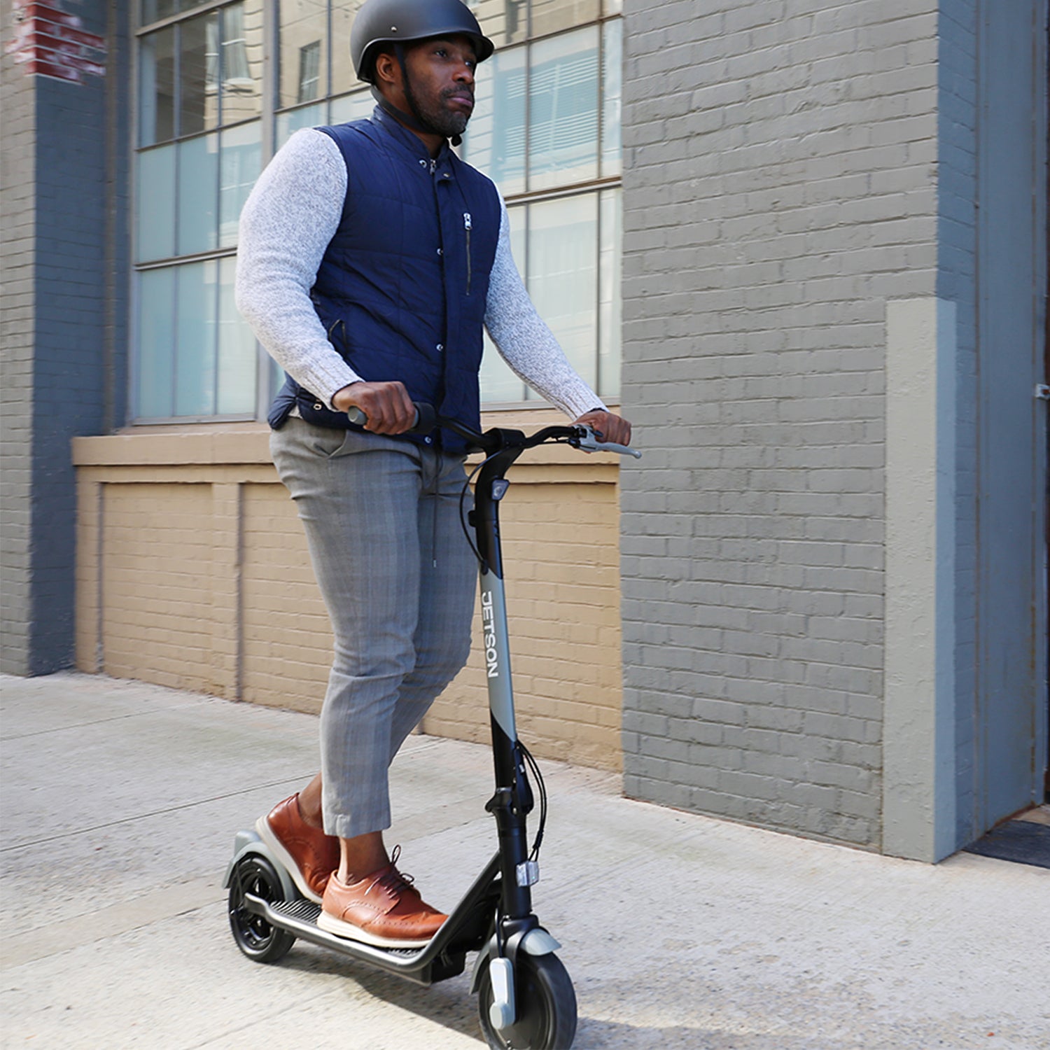 person in a helmet riding eris pro electric scooter