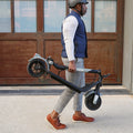 person carrying a folded eris pro electric scooter