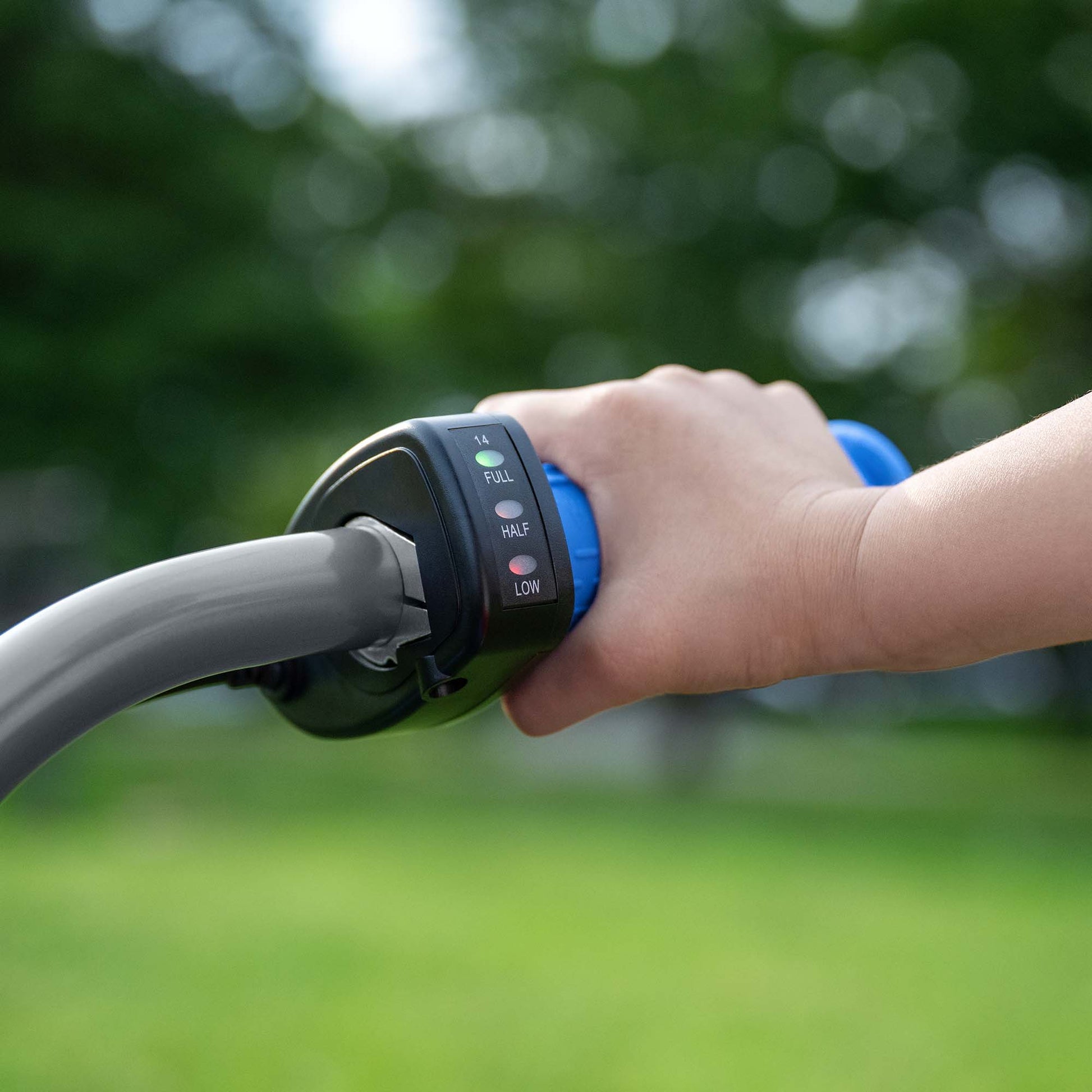 close up of battery indicator light with one hand on handle