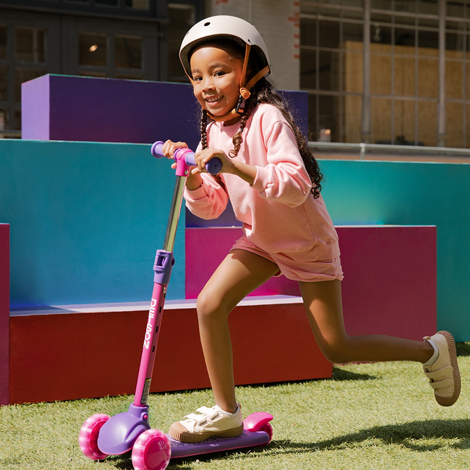 girl in a helmet riding pink gem kick scooter