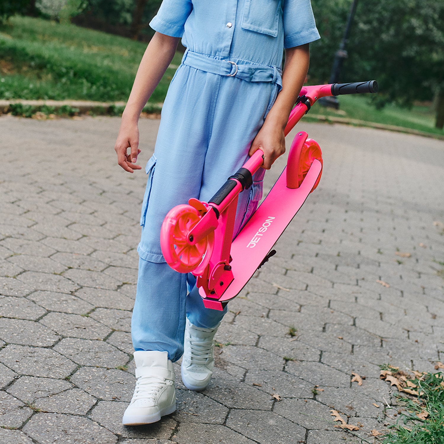 kid carrying folded pink highlight scooter